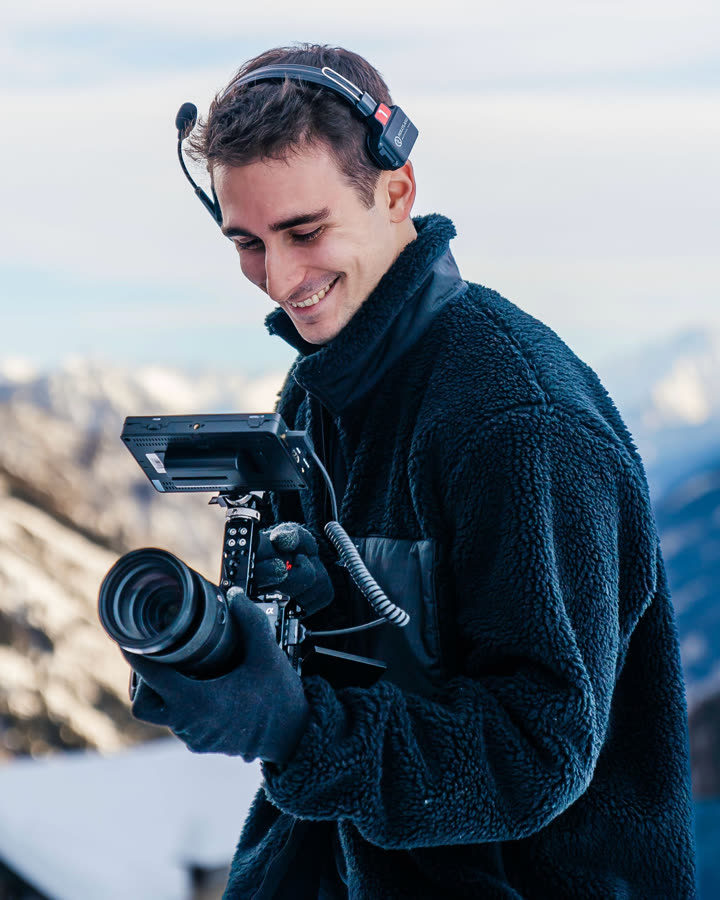 Ricky filming with a cinema camera rig in the mountains